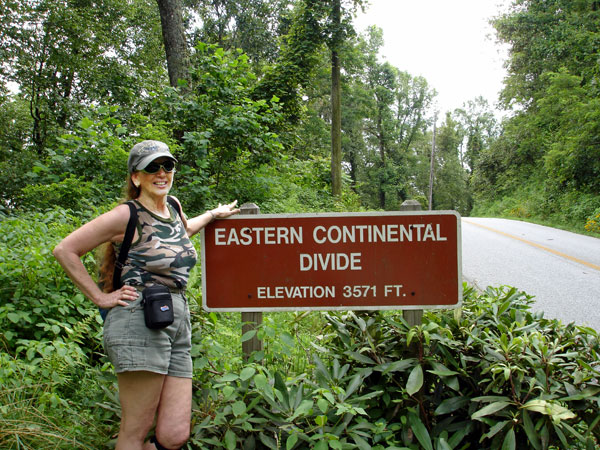 Karen Duquette at the Eastern Continental Divide sign